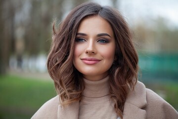 Fototapeta premium Carefree young woman brunette smiling, outdoor portrait