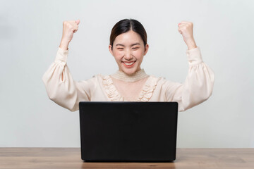 A young businesswoman is very happy after checking her email through her laptop.