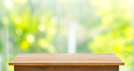 Selective focus.Empty wood table top on beautiful background of blur garden in the morning.