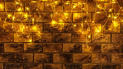 Glowing garland on masonry wall. Glowing garland on a brick wall. Festive background picture