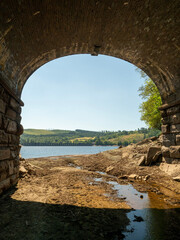 bridge over dried out river looking onto Lake Vyrnwy