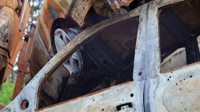 Russian invasion of Ukraine in 2022, destroyed and burned cars. The cars were beaten with shrapnel and burned. Irpinsky automobile cemetery. Consequences of the war in a peaceful city near Kyiv.