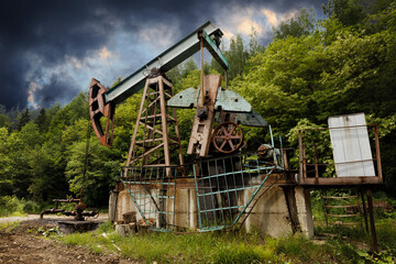 Fototapeta na wymiar Environmental pollution, old oil well and oil pump derrick.
