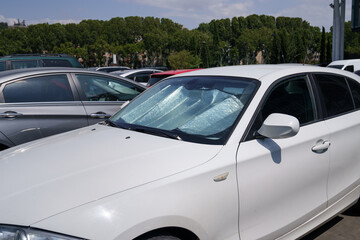 Closeup of protective reflective surface under the windshield of the passenger car parked on a hot day, heated by the sun's rays inside car. Sunshade, Heat protection, auto accessory concept