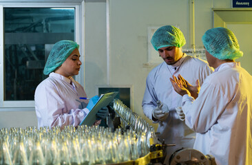 Product quality control officer in fruit juice production line Carry out an inspection of bottles...