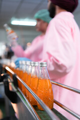 Product quality control staff at the fruit juice production line Perform product quality checks To ensure that the products produced are of good quality