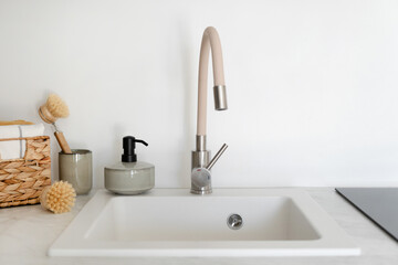 Fototapeta na wymiar New faucet above an empty white sink on kitchen