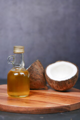 Obraz na płótnie Canvas slice of fresh coconut and bottle of oil on a table 