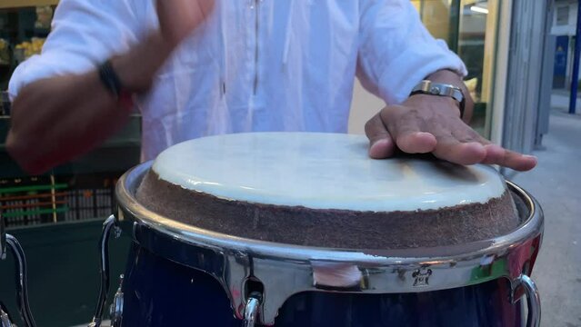 Close up of a unrecognizable musician playing the conga drums. Hands playing drums. Outdoor music activity. Summer festival with musicians. Drummer at work. High quality 4k footage