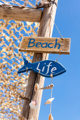 Wooden sign on the beach. Beach life. Summer signpost