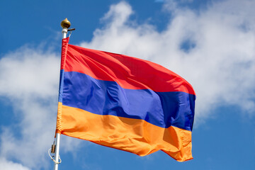 Flag of Armenia of  flies against a clear blue sky with white clouds. Close-up, perfect for news
