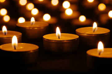 Fototapeta na wymiar Many burning candles with bokeh light background