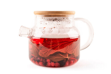 Tea made from berries and leaves of black and red currants in an elegant transparent glass teapot on a white isolated background. Template for the design. A drink rich in vitamin C.