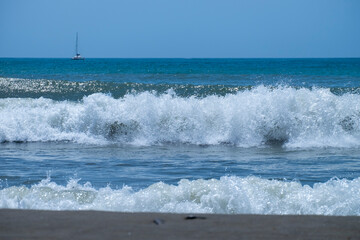 Ocean waves crashing on sandy beach. Sea waves breaking on Maditerranean's shore.