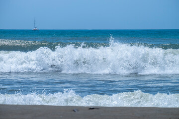 Ocean waves crashing on sandy beach. Sea waves breaking on Maditerranean's shore.