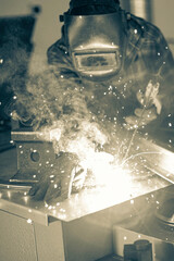 welder performing his work at a stationary post for electric arc welding