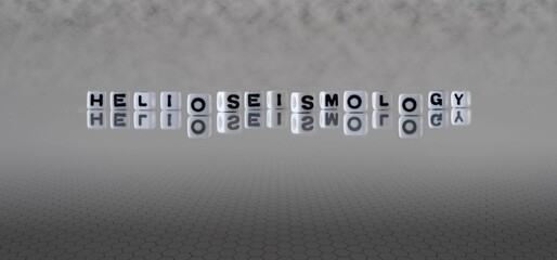 helioseismology word or concept represented by black and white letter cubes on a grey horizon background stretching to infinity