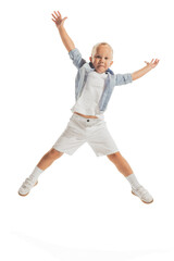 Portrait of little boy, child in casual outfit posing in a jump, having fun isolated over white studio background