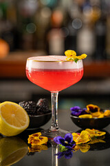Pink Gin and Lemon & Blackberry Cocktail with Pansy Garnish.