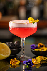 Pink Gin and Lemon & Blackberry Cocktail with Pansy Garnish.