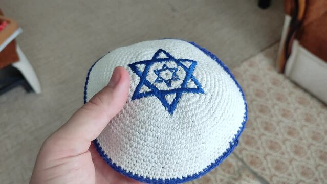Unrecognizable man holding a jewish kippah hat in his hands