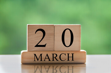 March 20 calendar date text on wooden blocks with blurred park background. Copy space and calendar...