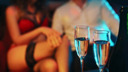 Woman flirting with man in strip club.