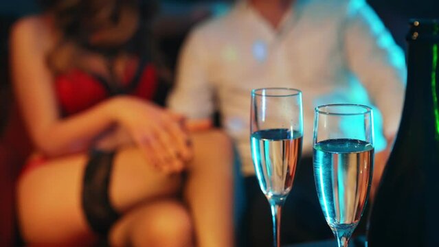 Woman flirting with man in strip club.