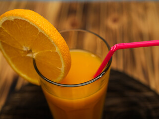 Full glass of orange juice close-up. Fresh orange juice on wooden table