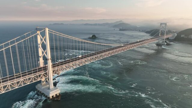 Strong current under suspension bridge across Naruto Straight at sunset