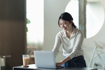 Beautiful young woman working on her laptop in her office.