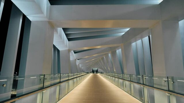 Hyperlapse inside a unique and modern pedestrian bridge with a futuristic, geometric, twisting design. 