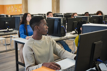 Young multiethnic students using computer inside university classroom