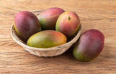 A group of ripe mangos over wooden table