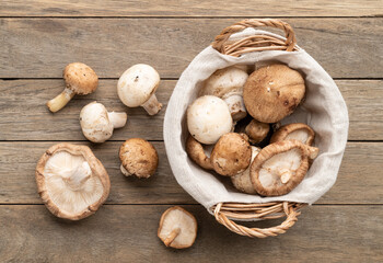Shitake, portobello and paris mushrooms in a basket over wooden table