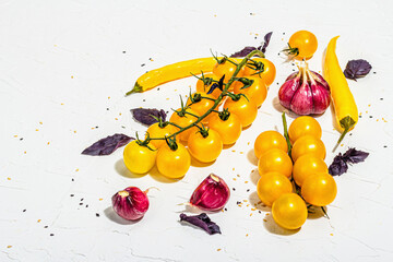 Culinary background with ripe vegetables. Yellow tomato cherries, chili pepper, garlic, purple...