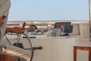 Hand of man on the steering wheel sailboat. Hands on the sailboat's steering wheel. Man's Hands...