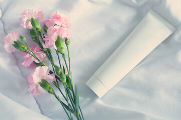 Tube of white cream and pink flowers