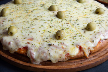 pizza de muzzarella con aceitunas recien horneada