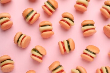 Tasty jelly candies in shape of burger on pink background, flat lay
