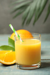 Glass of orange juice and fresh fruits on wooden table