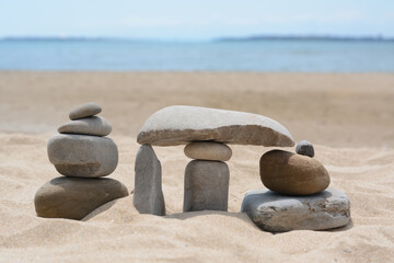 Stacks of stones on beautiful sandy beach near sea