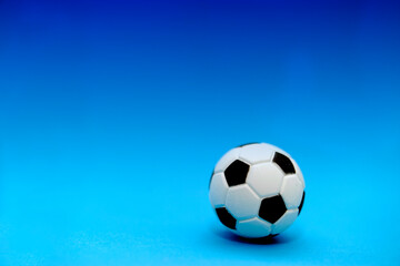 miniature soccer ball over blue background