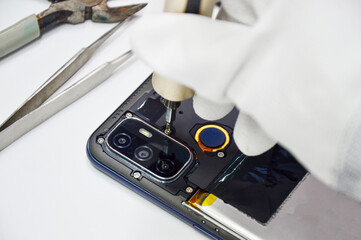 Image of a technician screwing the back of a mobile phone.
