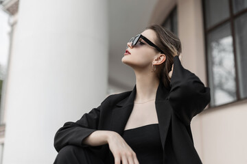 Beautiful young fashion urban elegant girl model with cool stylish sunglasses in fashionable black...