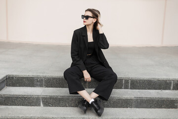 Stylish beautiful elegant model girl with fashion cool sunglasses in fashionable black business...