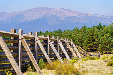 Wooden fence against the strong wind coming down from the top of the mountain in the Community of Madrid, Spain.