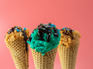 Turquoise blue and caramel ice cream on a pink background.