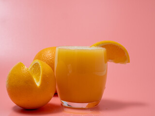 Orange and orange slice. Orange Juice Splashing. Orange on a pink background.