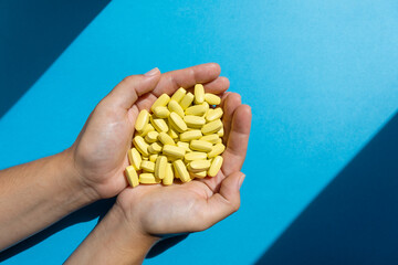 Hands of doctor holding a lot of medicine vitamin capsules or pills. Healthcare or medical concept.